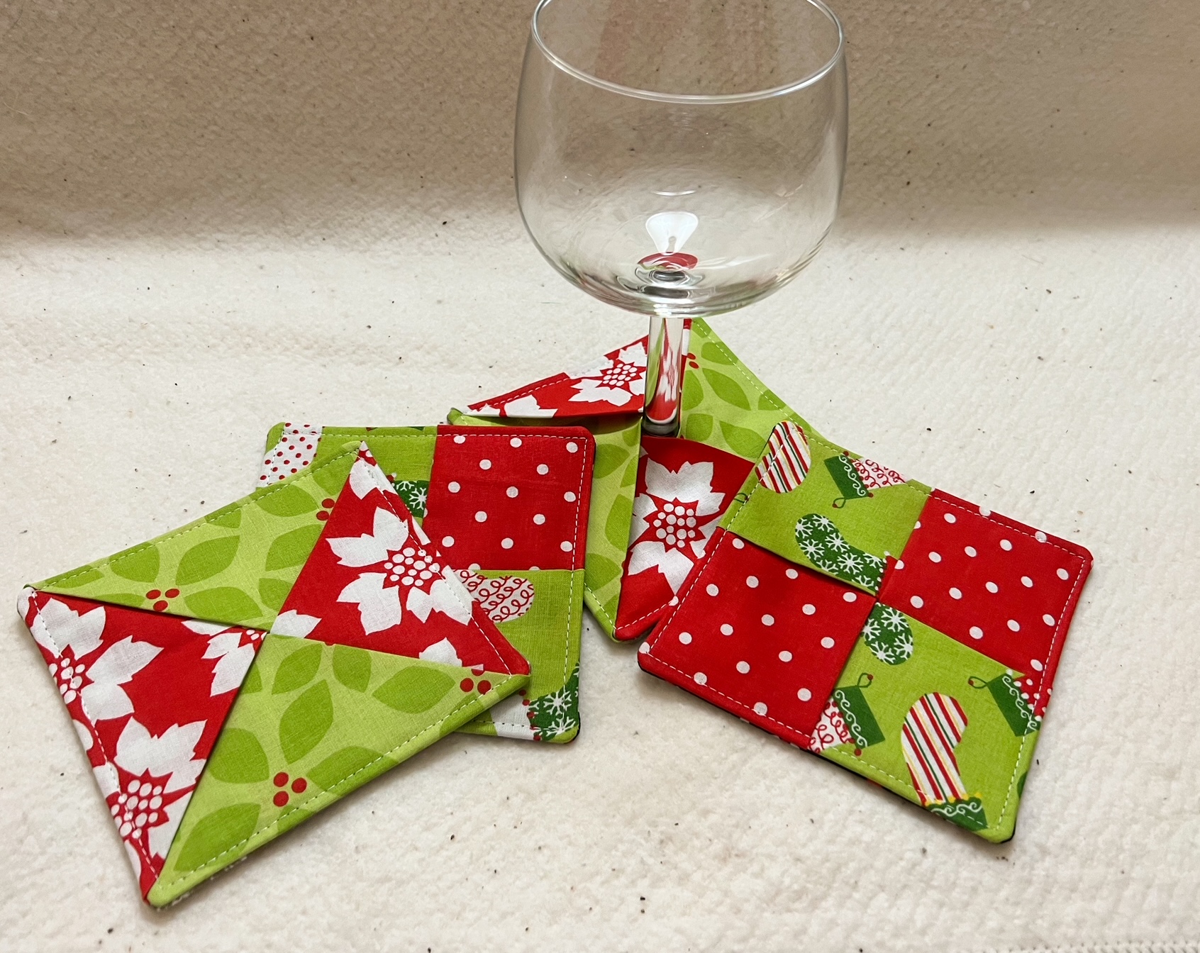 Red and green holiday coasters with wine glass