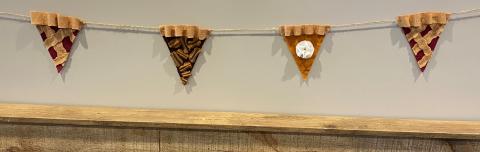 Felt garland in the shape of a cherry pie slice, pecan pie slice, and pumpkin pie slice.