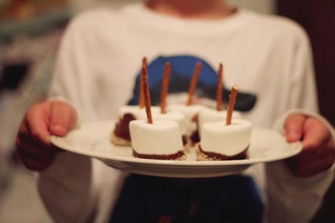 A photo of a person holding several s'more pops