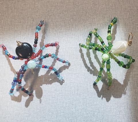 two beaded spiders made from wire and green, black, red and blue beads