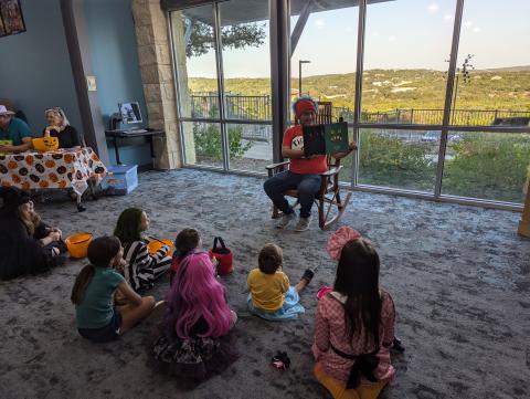 Mr. Javier reading a picture book in costume