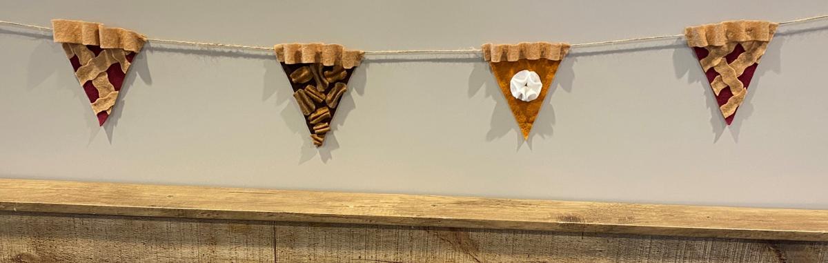 Felt garland in the shape of a cherry pie slice, pecan pie slice, and pumpkin pie slice.